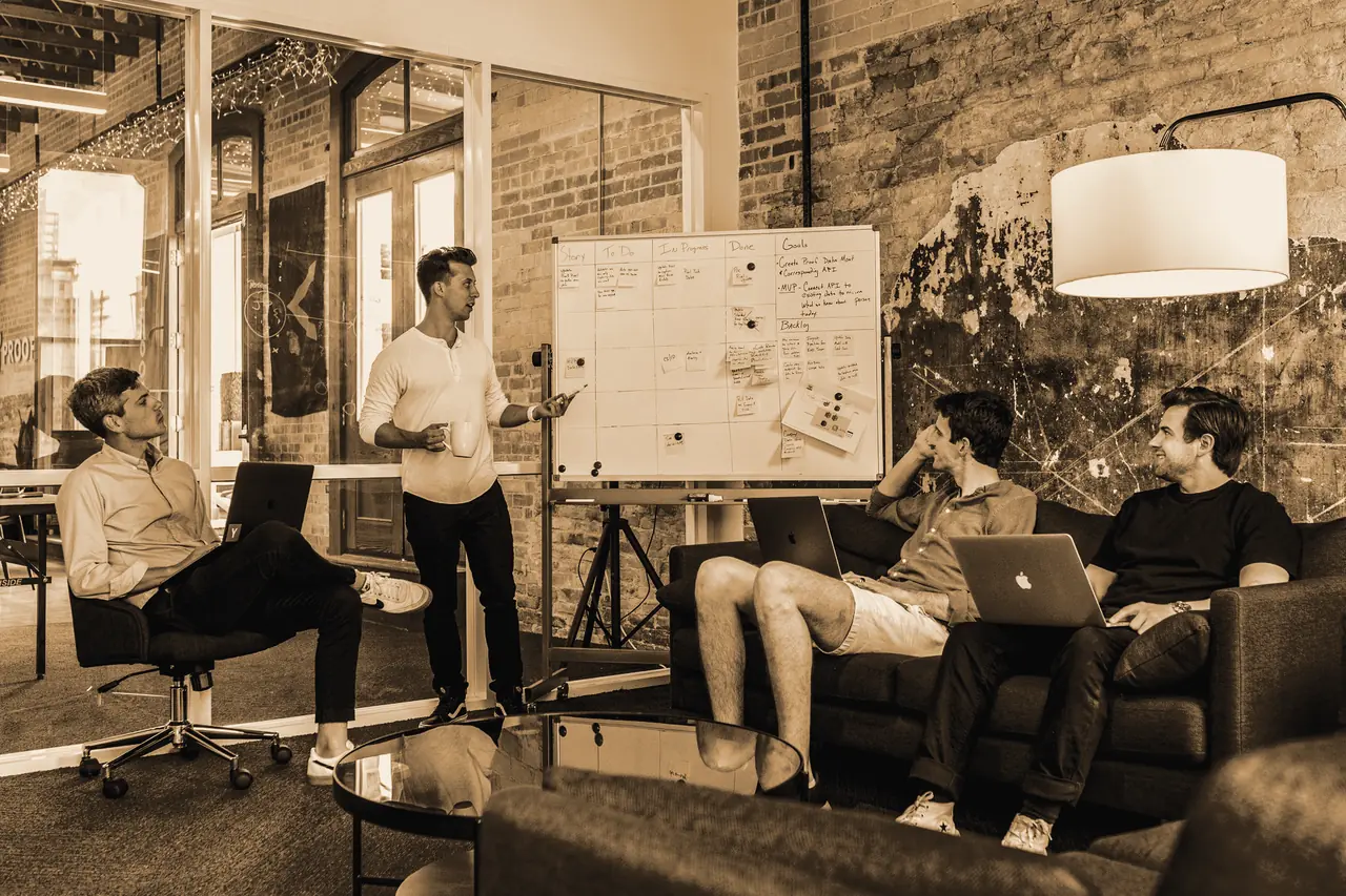 Atelier collaboratif devant un tableau couvert de notes